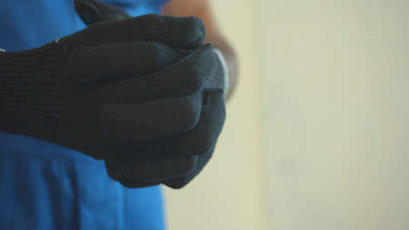 Close up, man in uniform puts on protective glovesの写真素材