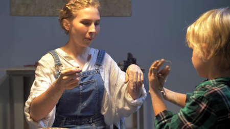 Boy and woman works with pottery wheel in the workshop