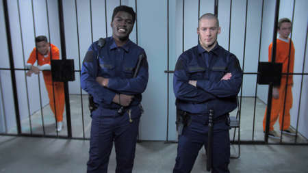 Prison guards stand near prison cells