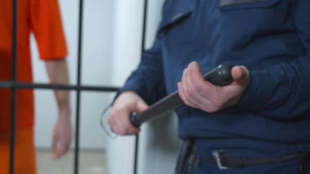 The jailer holds a baton in his hands. Close upの写真素材