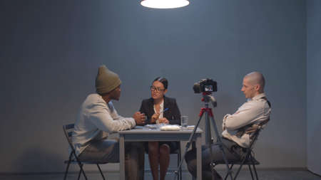 Lawyer talking to a suspect under the eyes of a policeman