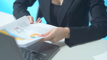 Woman is typing and receives a report from a colleagueの写真素材