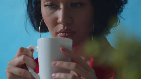 Beautiful girl drinks coffee from a mug. Close-upの写真素材