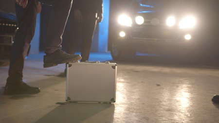 Mafia passes a suitcase with money in the parking lotの写真素材