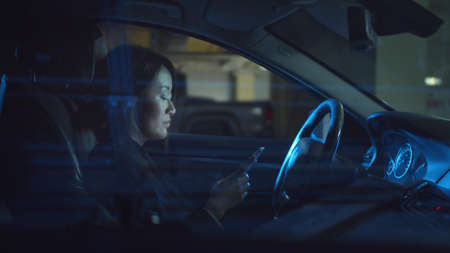 Woman in a car typing a message on the phone
