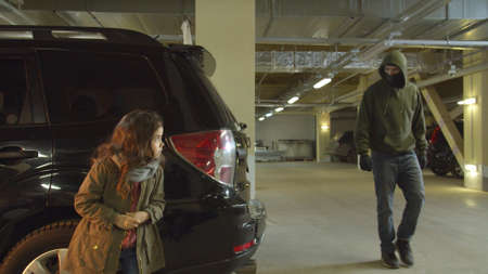Girl hiding from a kidnapper in the parking lotの写真素材