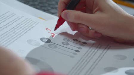 Woman puts marks in documents with markerの写真素材