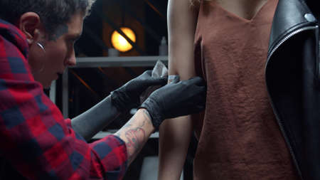 Girl puts temporary tattoo on arm of a clientの写真素材