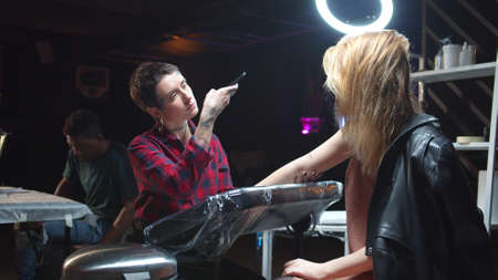 Tattooist makes photo of just made tattooの写真素材