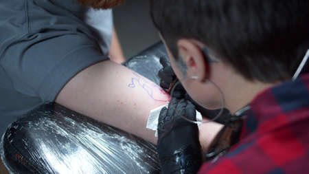 The girl stuffs a tattoo with a picture of a bull. Close-upの写真素材