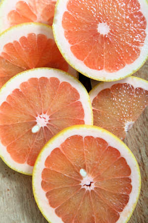 Fresh slices of pink grapefruit on a woodcutterの写真素材