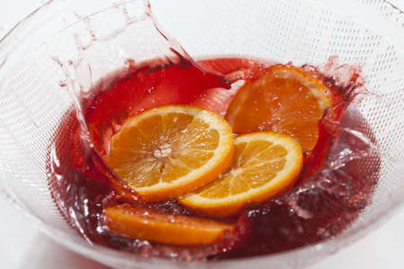 Orange slices splash in orange juiceの写真素材