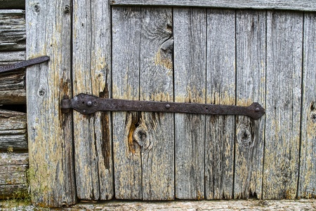 Rusty hinge on an old wooden door of a barn in the mountains in Italyの写真素材