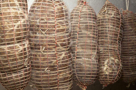 Salami Italian handmade hanging to mature in the cellar