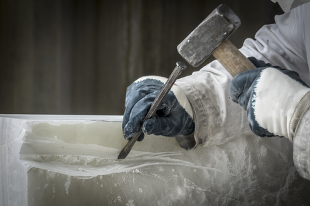 Detail of artist's hands sculpting marble with hammer and chiselの写真素材