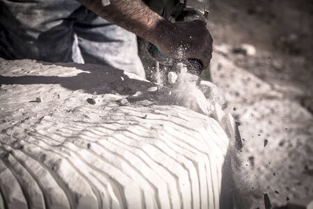 Artist sculpting marble with pneumatic hammerの写真素材