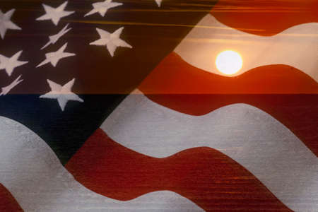 American flag and bright sunshine on ocean - USA patriotic conceptの写真素材