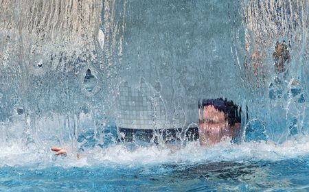 Woman at spa under waterfall showerの写真素材