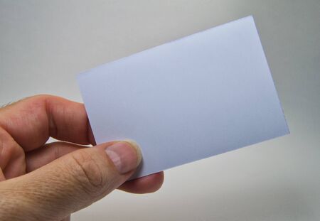 man hand holding a gray empty billboard on a gray backgroundの写真素材
