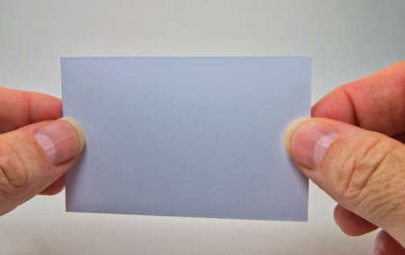 man hand holding a gray empty billboard on a gray backgroundの写真素材