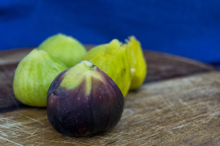 Fresh tasty figs fruits on a wood plate with bread and a blue background. for healthy and natural concepts. Ficus Caricaの写真素材