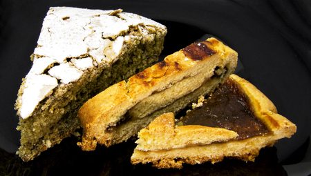 Slices of three different homemade tarts and pie on a black dish. For food conceptsの写真素材