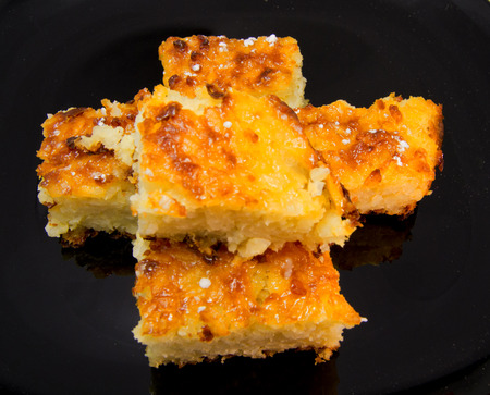 Baked rice pudding dessert sweetened with sugar powder on black dish. for food conceptの写真素材