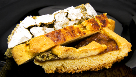 Slices of three different homemade tarts and pie on a black dish. For food conceptsの写真素材