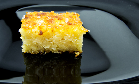 Baked rice pudding dessert sweetened with sugar powder on black dish. for food conceptの写真素材