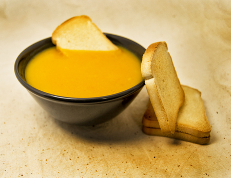 delicious pumpkin pured soup with potatoes and zwiebacks bread slices. for vegetarian, vegan and healthy conceptの写真素材