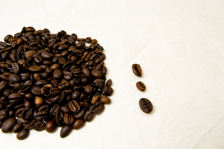 close up of roasted coffee beans with white background with space for text. to be used as background or textureの写真素材