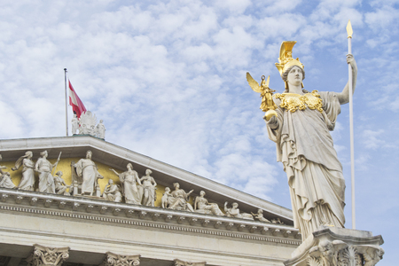 austrian parlament with Athena statue and flag on cloudy sky used as backgroundの写真素材