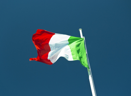 italian flag waving in the wind with blue sky as background.の写真素材
