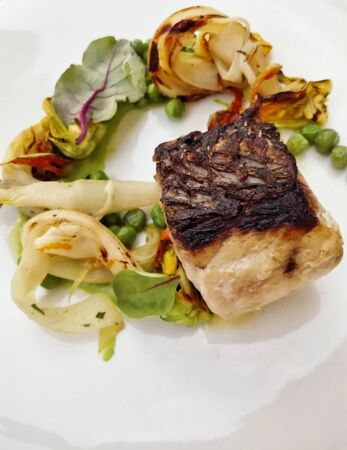 roasted veal loin with peas, corn and vegetables. second dishの写真素材