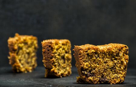 homemade tart slices on a black background with chocolate, italian amaretti cookies, nuts and yogurthの写真素材