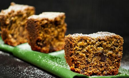 homemade tart slices on a black background with chocolate, italian amaretti cookies, nuts and yogurthの写真素材