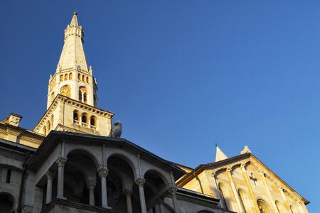 ghirlandina bells tower and facade of the duomo of Modena with blue sky - 700 years fron the construction of the tower (1319 - 2019)の写真素材