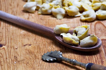 handmade and homemade tortellini on a wooden chopper board. Typical products of Modena and Bologna, Emilia Romagna region, Italy. Traditional foodの写真素材