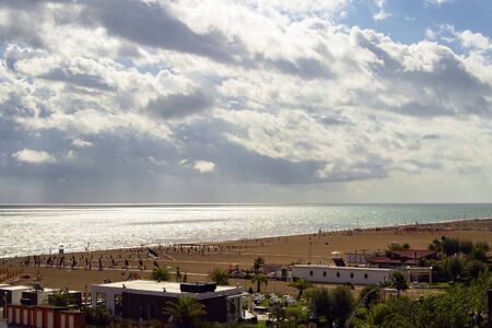 Summer concept: mediterranean italian beach with sand and parasols, cloudy sky, nobody present. の写真素材