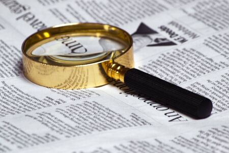 old style magnifying glass lens and newspaper. concept for fact checking, politicsの写真素材