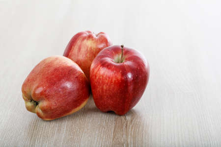 Red apples on a wooden surface