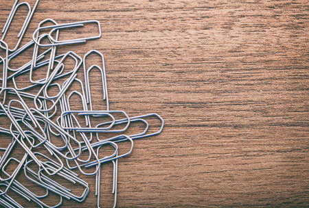 Paperclips spread on a wooden surfaceの写真素材