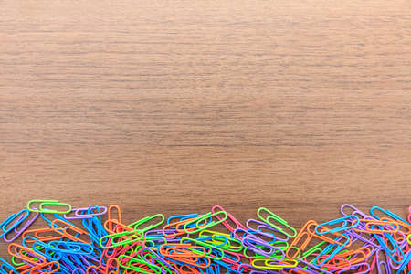 Colorful paperclips on a wooden surfaceの写真素材
