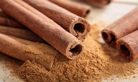 Cinnamon sticks and powder on a wooden surfaceの写真素材