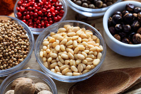 Pine nuts and other spices on a wooden surfaceの写真素材