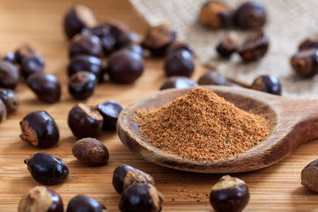 Guarana nuts and powder on a tableの写真素材