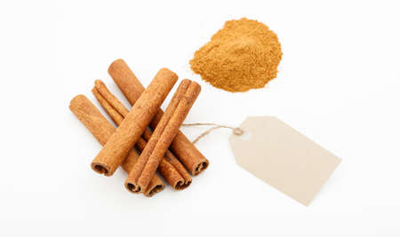 Cinammon sticks and powder with label on a white backgroundの写真素材