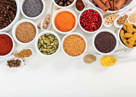 Bowls and spoons with spices composition on white backgroundの写真素材