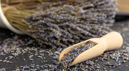 Dried lavender bunch and wooden scoop on black backgroundの写真素材