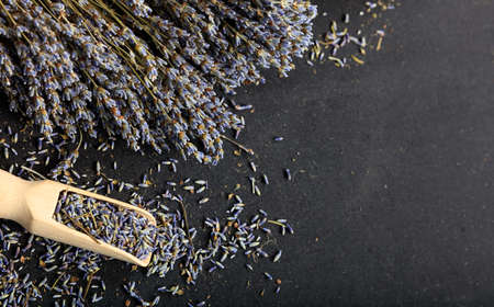 Dried lavender bunch and wooden scoop on black backgroundの写真素材